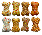 Eight mini bone-shaped dog cookies with fall-colored coatings, drizzle, and sprinkles on a wooden tray surrounded by pumpkins.