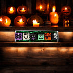 Assorted Halloween dog truffles with ghost, monster, pumpkin, and spiderweb designs displayed on a rectangular tray.
