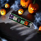 Assorted Halloween dog truffles with ghost, monster, pumpkin, and spiderweb designs displayed on a rectangular tray.