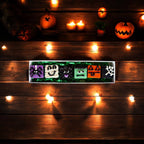 Assorted Halloween dog truffles with ghost, monster, pumpkin, and spiderweb designs displayed on a rectangular tray.